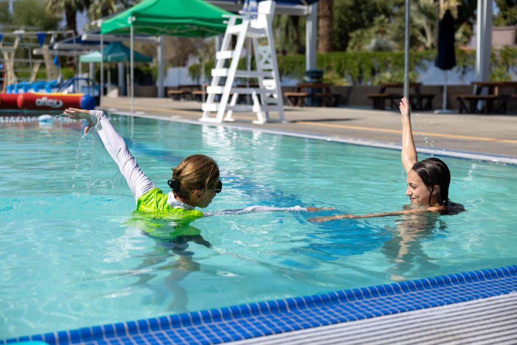 Swim instructor and student conducting their lesson in the pool.